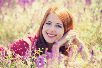 Redhead girl at green grass at village outdoor