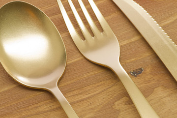 Spoon, fork and knife on wooden table