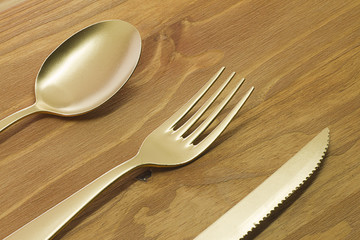 Spoon, fork and knife on wooden table