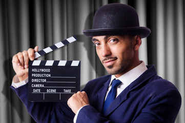 Man with movie clapper on curtain background