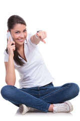 casual woman sits & points on phone