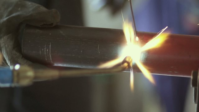 Operaio mentre salda un tubo