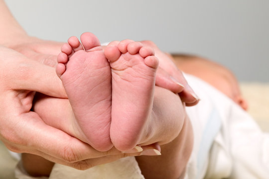 Mother is holding legs of baby boy