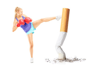 Female with boxing gloves kicking with her leg a cigarrette butt