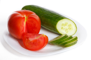 Slised tomatoes and cucumber on a white plate