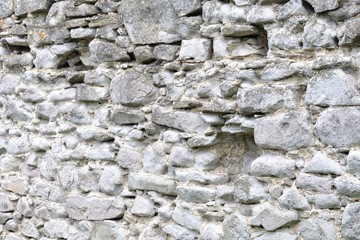 Surface of light gray vintage stone wall at old building