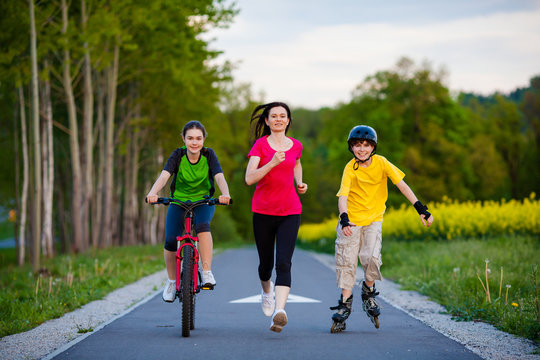 Active family - mother and kids running, biking, rollerblading
