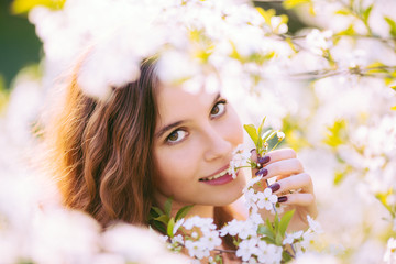 Young woman enjoying smell of blooming tree