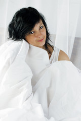 JEUNE FEMME DANS UNE COUETTE DE LIT