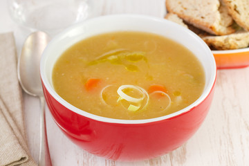 vegetable soup in red bowl with bread