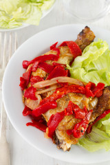 chicken with pepper and salad on the plate