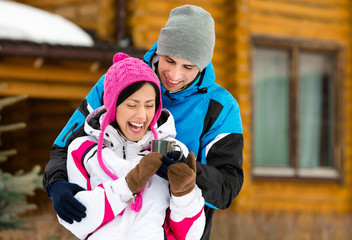 Half-length portrait of hugging couple who drinks tea outdoors 