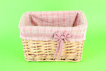 Obraz premium Woven wicker basket with pink gingham liner and polka dot bow, empty storage container for home organization, the natural wood material and rustic design add a touch of warmth to any interior space