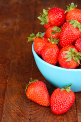 Fresh strawberry in bowl on wooden background