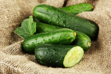 Tasty green cucumbers on sackcloth background