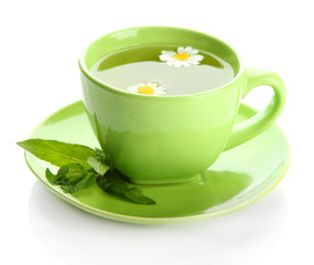 Cup of herbal tea with wild camomiles and mint, isolated