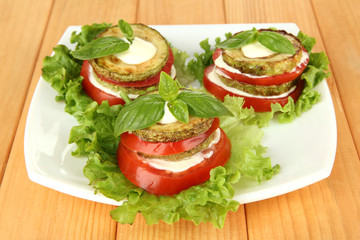 Tasty roasted marrow and tomato slices with salad leaves,
