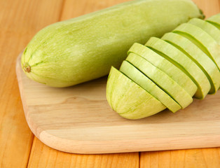 Fresh marrows on cutting board, on wooden background