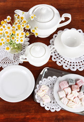 Table setting with chamomiles on wooden table
