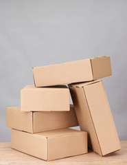 Parcels boxes on wooden table, on grey background