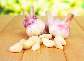 Fresh garlic on wooden table, on bright background