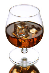 Brandy glass with ice on grey background