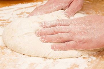 Fototapeta na wymiar Pair of hands kneading dough
