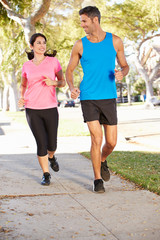 Couple Running On Suburban Street