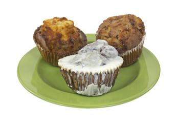Fresh muffins on green plate