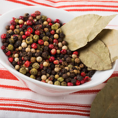 Mixed pepper in white bowl on wooden background