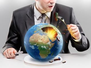 Greedy businessman eating planet Earth