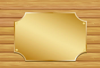 Golden plate on wooden background.