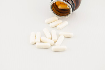 White capsule on brown bottle background