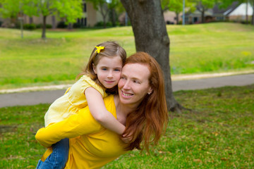 Fototapeta premium Daughter and mother piggyback smiling in park outdoor
