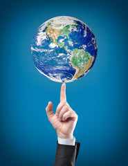 earth globe on top on businessman finger