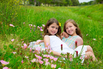 children friends girls on spring poppy flowers meadow