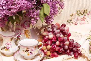 Obraz na płótnie Canvas Vintage teacup with spring flowers and grape