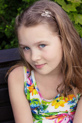 Beautiful young girl is sitting on the bench
