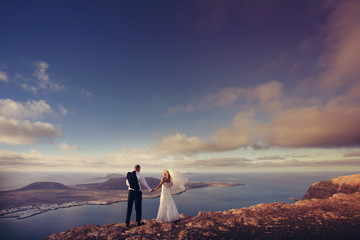 Newlyweds staring at the horizon in Canary Islands.