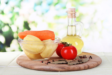 Peeled vegetables in bowl on bright background