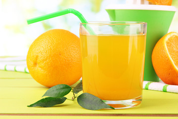 Glass of juice, citrus press and ripe orange