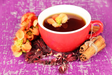 Herbal tea in cup, on color wooden background