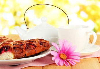 Cherry Pie with tea on table on bright background