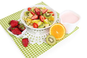 Useful fruit salad of fresh fruits and berries in bowl isolated