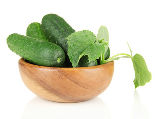 Tasty green cucumbers in wooden bowl, isolated on white