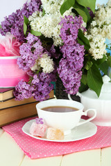 Composition with beautiful lilac flowers, tea service