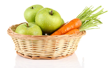 Juicy green apples and carrots with leaves in basket, isolated