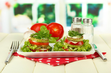 Tasty roasted marrow and tomato slices with salad leaves,