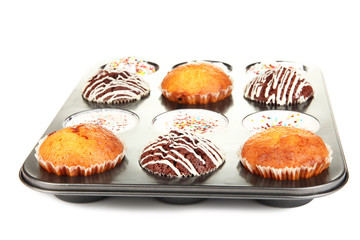 Tasty muffin cakes in baking tray isolated on white