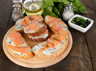Fish sandwiches on cutting board on wooden table